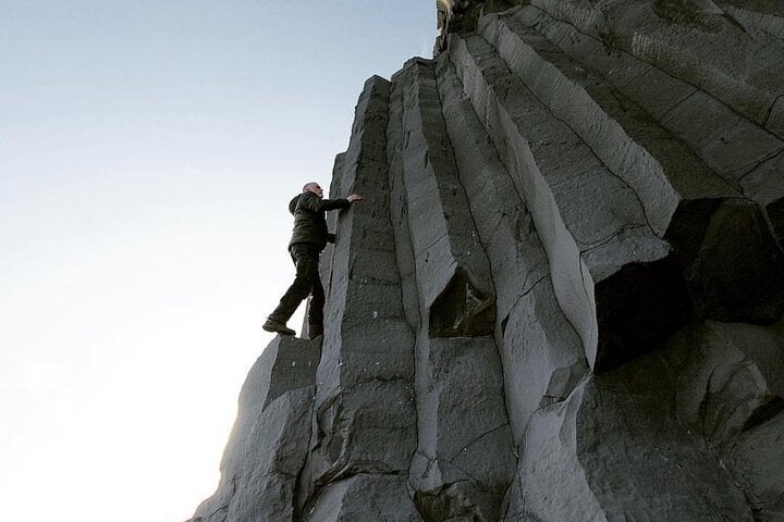 Marvel at the mesmerizing columnar basalt formations standing tall at Reynisfjara's black sand beach.