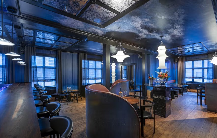 Elegant Reykjavik cocktail lounge with modern lighting, dark wood interiors and stylish seating at Uppi Bar.