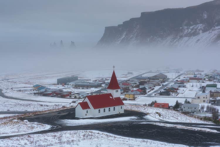 The town of Vik is enveloped in mist during the winter season.