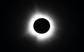 The sun's corona shines aorund the mooon on a solar eclipse tour in Iceland.