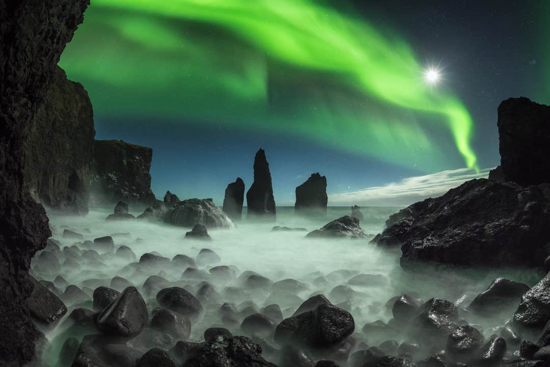 Auroras boreales sobre los pilares de mar en la península de Reykjanes durante un tour nocturno desde Reikiavik.