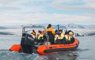Tourists wearing safety suits on a zodiac boat tour at Jokulsarlon Glacier Lagoon.