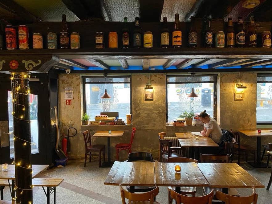 Interior of Aegir 101 with rustic wooden tables, beer bottle decor, and a relaxed atmosphere.