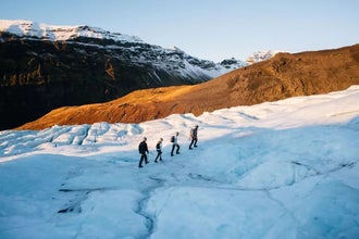 Group of hikers walking on Falljokull glacier in Skaftafell under winter sunlight.