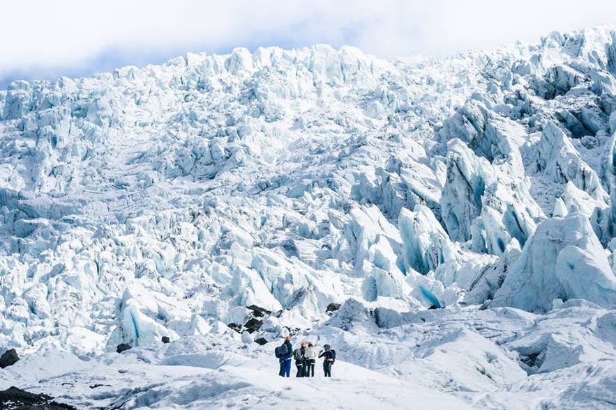 Gruppo di escursionisti che cammina sulla superficie ghiacciata del ghiacciaio Falljokull, una lingua glaciale del Vatnajokull nel sud dell'Islanda.