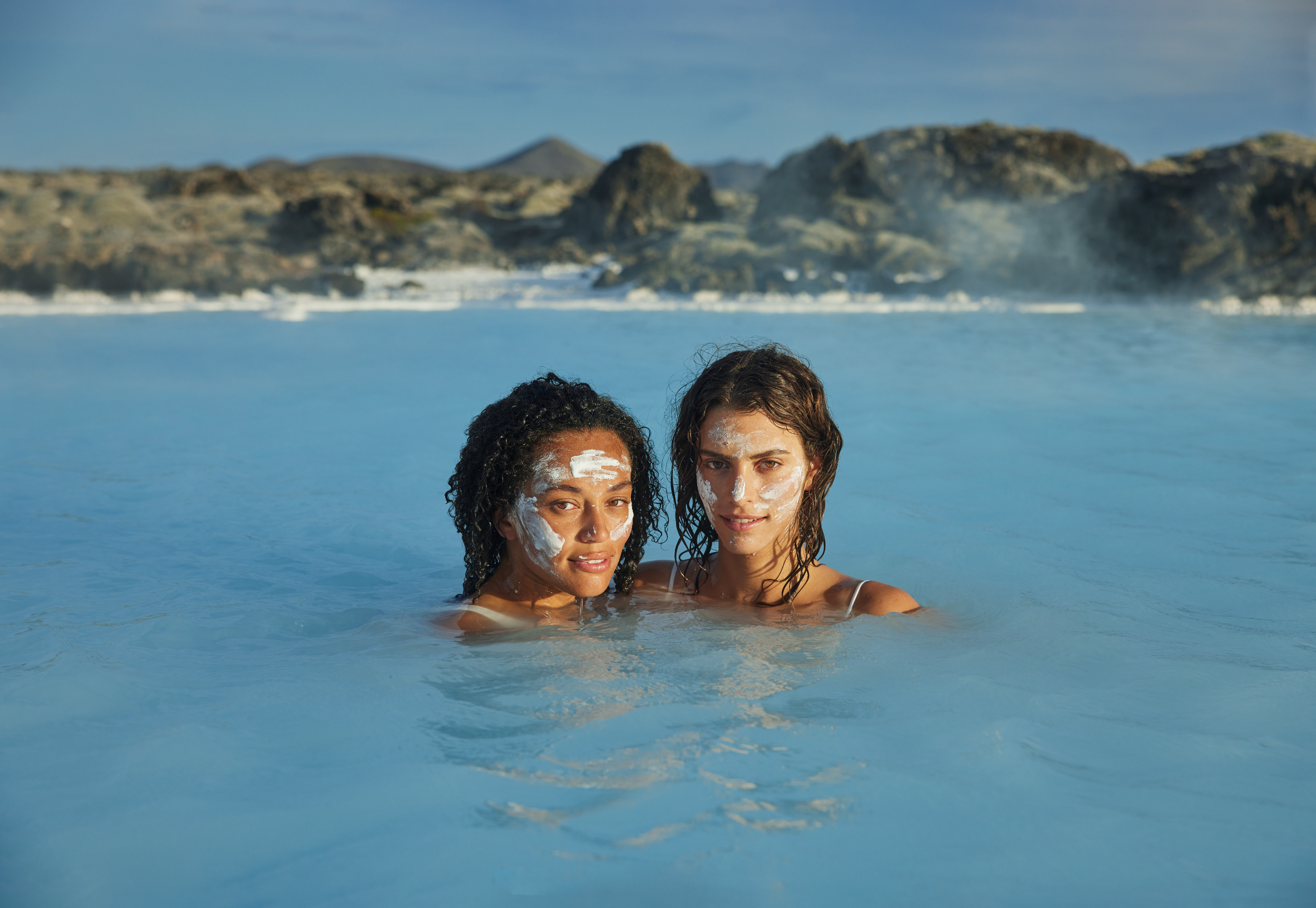 Two women relaxing in the Blue Lagoon’s warm geothermal waters in Iceland.