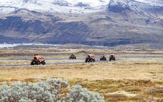 ATV group adventure with snow-capped glaciers and dramatic mountain scenery in Skaftafell, Iceland.