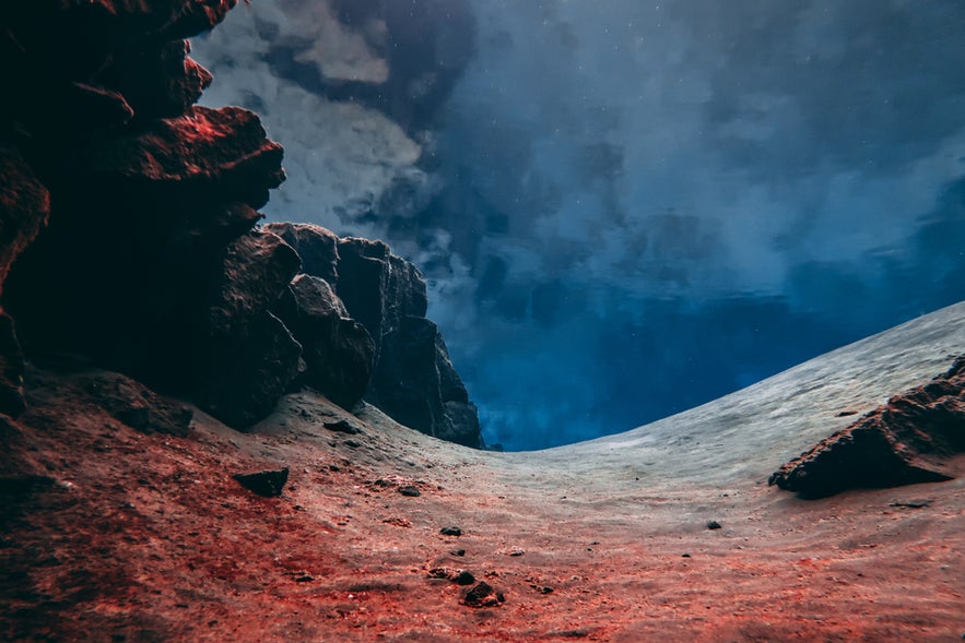 Underwater view of Silfra Fissure in Thingvellir National Park, Iceland, showing clear water and volcanic rock formations.