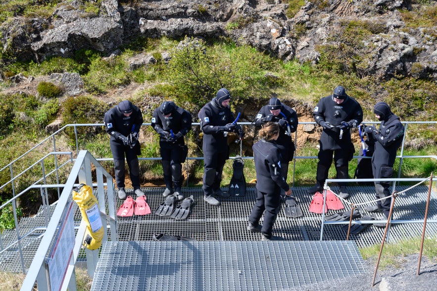 Snorkelers preparing gear at the Silfra entry platform in Thingvellir National Park, Iceland.