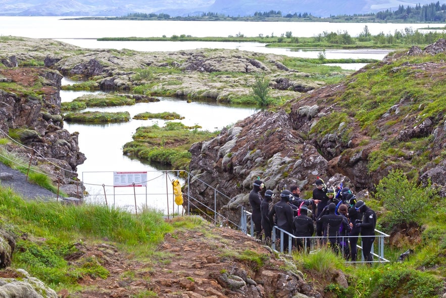Group of snorkelers preparing to enter Silfra Fissure in Thingvellir National Park, Iceland.