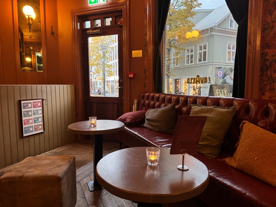 Interior view of Elly Bar showing candlelit tables near the front door and large windows overlooking Reykjavik’s street.