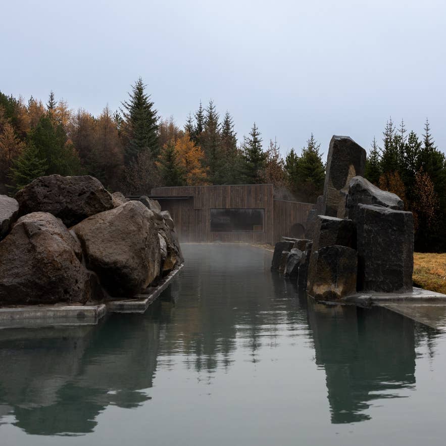 Парящая геотермальная лагуна, окружённая базальтовыми скалами в Laugarás Lagoon на Золотом кольце Исландии
