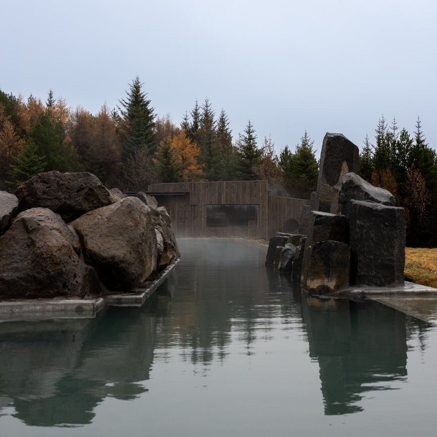 Steaming geothermal pool surrounded by basalt rocks at Laugarás Lagoon in Iceland’s Golden Circle