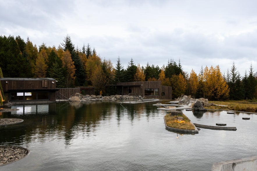 Modern spa buildings beside geothermal lagoon surrounded by autumn trees at Laugarás Lagoon Iceland Modern spa buildings beside geothermal lagoon surrounded by autumn trees at Laugarás Lagoon Iceland