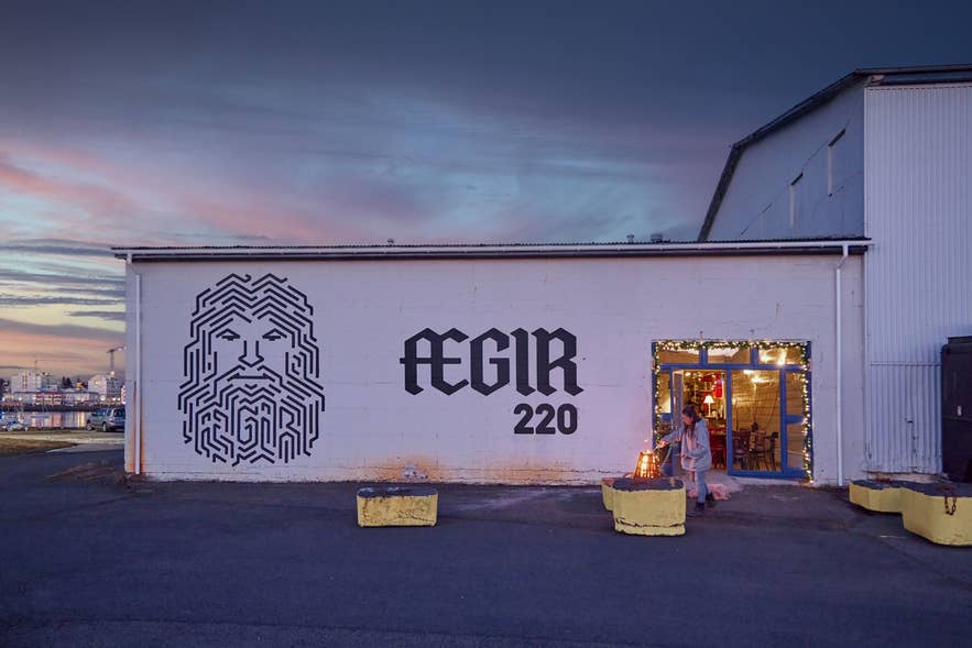 冰岛哈夫纳夫约杜尔Ægir 220酒吧和餐厅的外观，夕阳下可见墙面壁画。