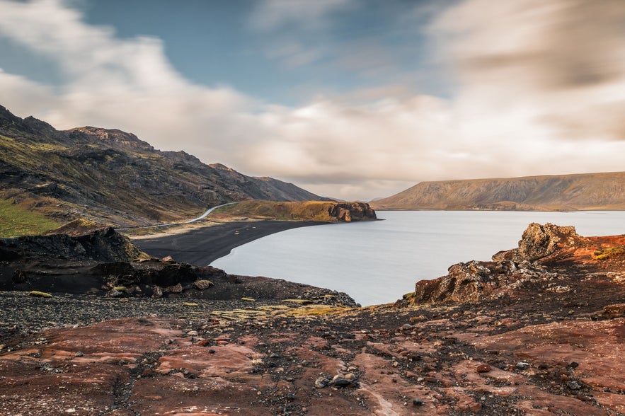 Scenic view of Kleifarvatn lake surrounded by volcanic cliffs and black sand in Reykjanes Peninsula, Iceland