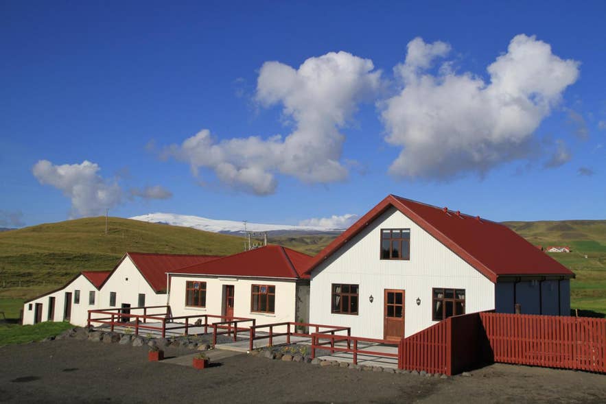 Solheimahjaleiga Guesthouse，一座红色屋顶的住宿，适合前往DC-3飞机残骸的游客。