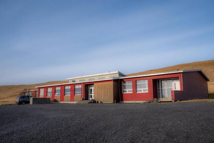 Volcano Hotel，一座依山而建的红色建筑，位于DC-3飞机残骸附近。