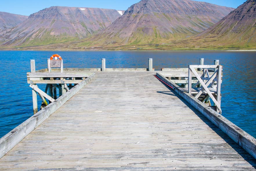 Der Onundarfjördur-Pier erstreckt sich in das ruhige, blaue Wasser und ist von Bergen und der atemberaubenden isländischen Natur umgeben.