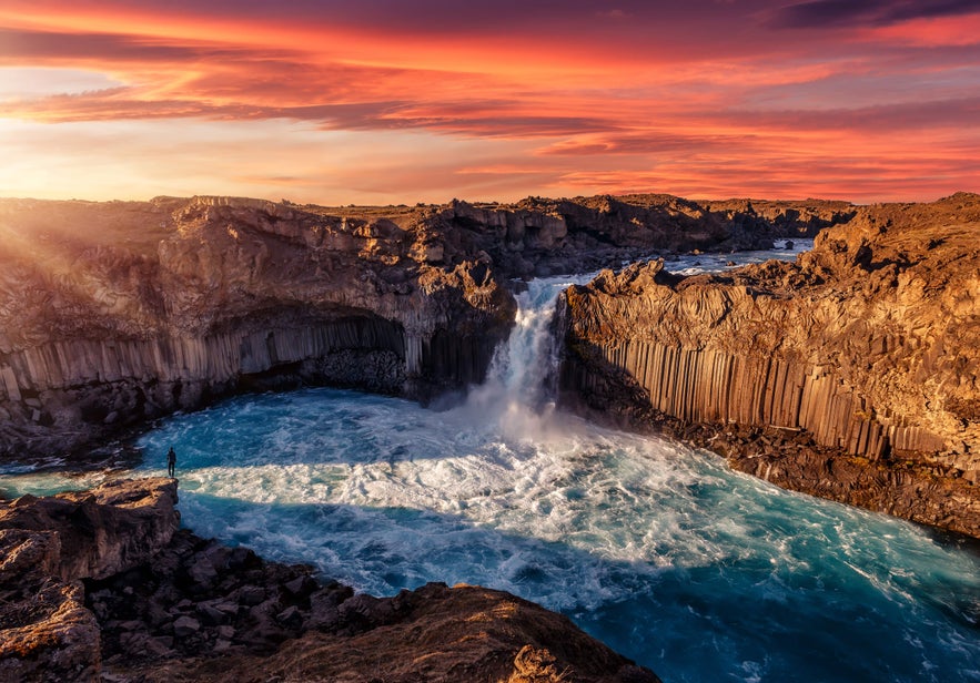 Aldeyjarfoss waterfall cascades over basalt columns into a blue pool, showcasing the dramatic natural beauty of Iceland