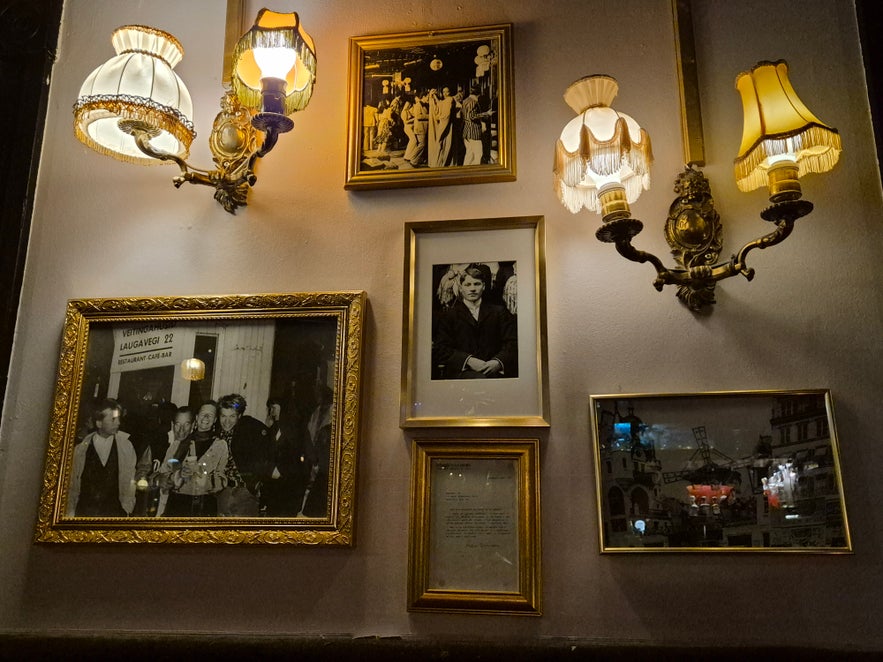 Wall inside 22 Bar decorated with framed vintage black-and-white photographs and ornate brass lamps. Wall inside 22 Bar decorated with framed vintage black-and-white photographs and ornate brass lamps.