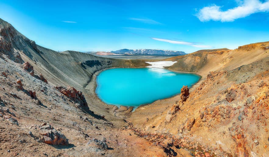 冰岛北部克拉夫拉火山区的维提火山口湖，湖水呈碧蓝色，周围是崎岖的火山坡。