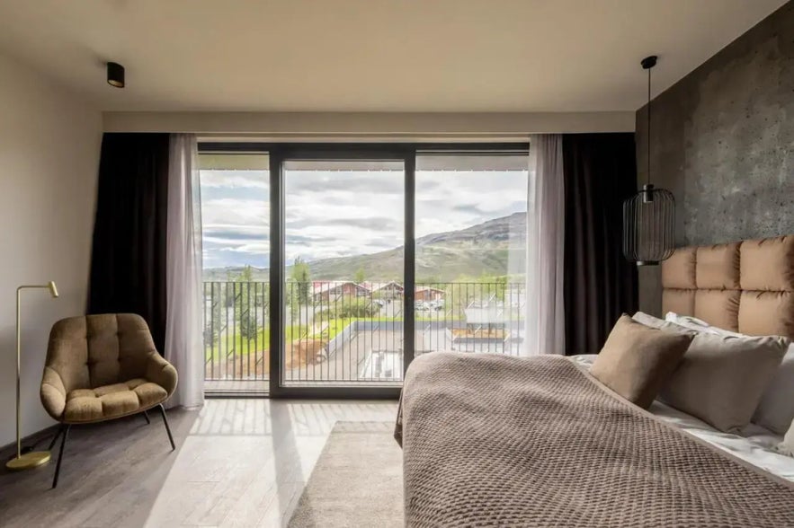Luxurious bedroom with modern decor and stunning mountain views, located at Hotel Geysir near the Geysir Geothermal Area.