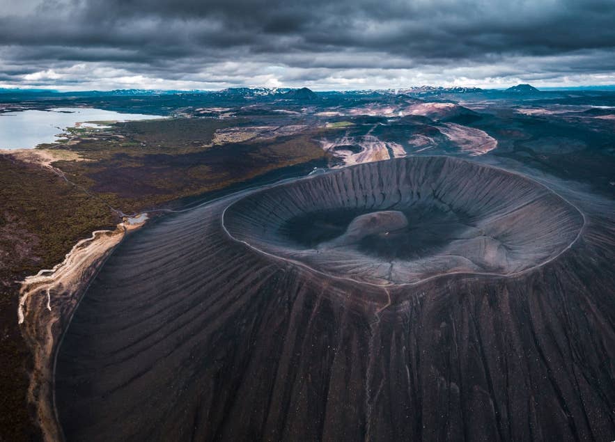 冰岛北部纳马菲亚尔地热区附近的赫维尔菲亚特火山口在戏剧性云层下的航拍图。