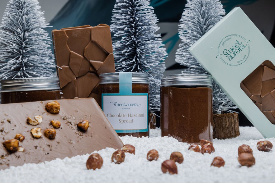 Sweet Aurora Reykjavik’s chocolate hazelnut spread jars and artisanal chocolate bars with hazelnuts in snowy holiday display.