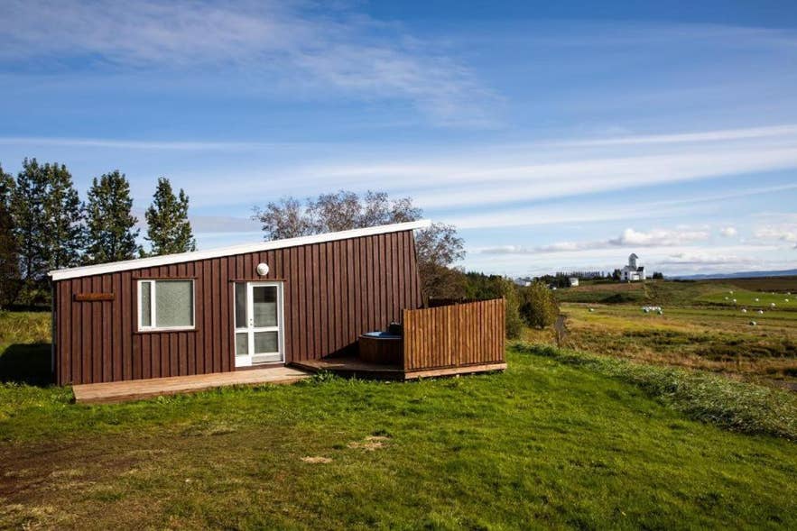 Un chalet rustique au cœur d'un champ, idéal pour les voyageurs en quête de confort et de découvertes culturelles à proximité de la cathédrale de Skalholt et du Cercle d'or.