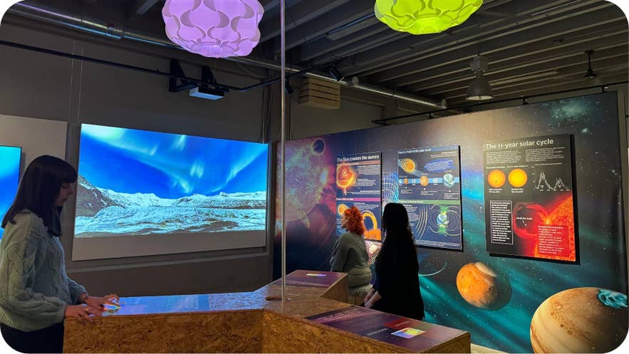 Visitors exploring northern lights displays and solar cycle exhibits at Aurora Reykjavik in April.