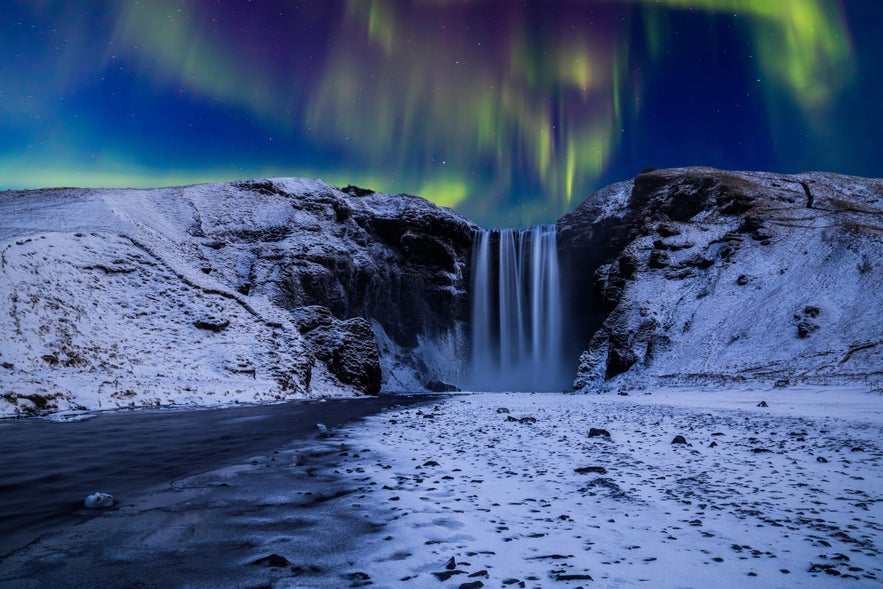 Northern lights above the cascading waters of Skogafoss on the South Coast of Iceland.