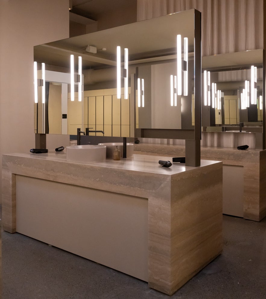 Elegant vanity station with mirrors and soft lighting inside the changing rooms at Laugarás Lagoon in Iceland Elegant vanity station with mirrors and soft lighting inside the changing rooms at Laugarás Lagoon in Iceland