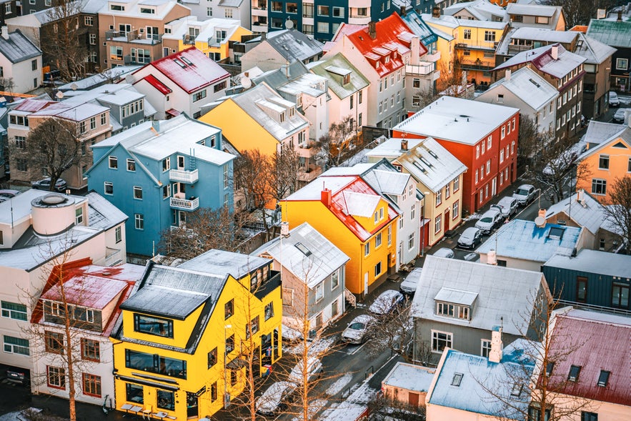 Colorful houses with snow-covered rooftops in downtown Reykjavik, Iceland, viewed from above during winter.