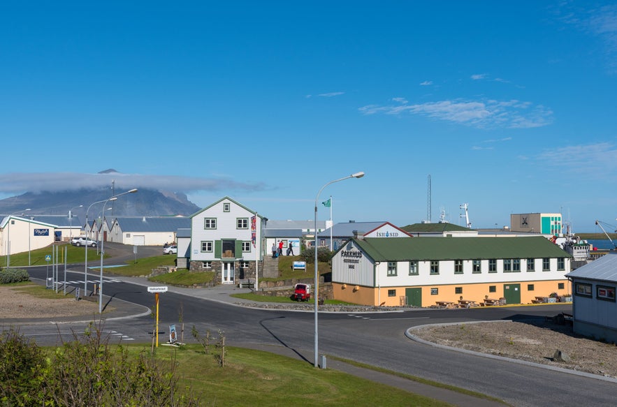 Kolorowe budynki w rybackim miasteczku Hofn w południowo-wschodniej Islandii z górami i błękitnym niebem w tle.
