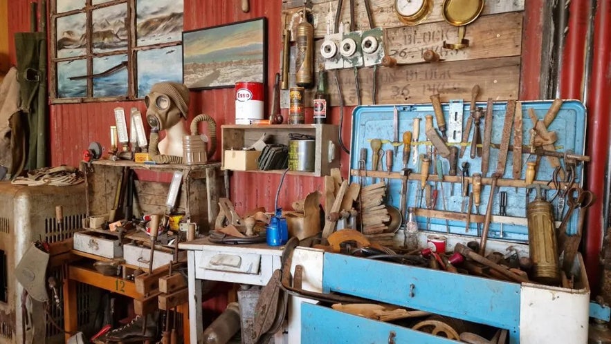 Historic workshop filled with vintage tools and equipment inside the War and Peace Museum in Iceland.