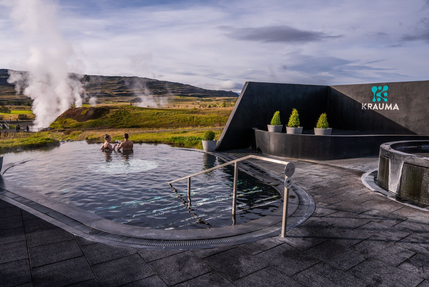 Couple relaxing in outdoor geothermal pool at Krauma Spa near Deildartunguhver in West Iceland.