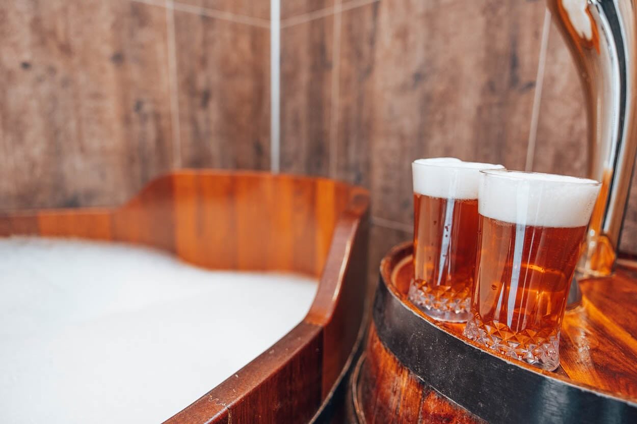 Beer bath spa experience in North Iceland with beer served beside the tub.