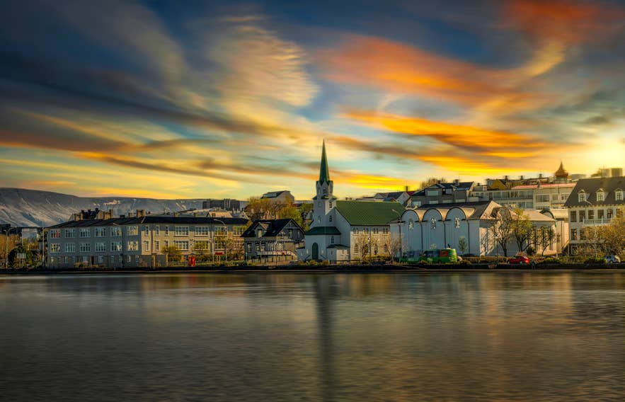 Sunset sky over Tjornin and Frikirkjan Church, capturing the calm beauty of Reykjavik in May
