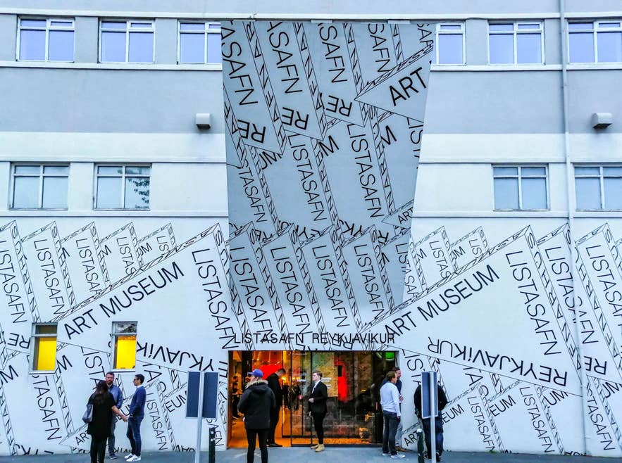 Exterior of the Reykjavík Art Museum Hafnarhús with bold graphic façade and visitors gathered outside in downtown Reykjavík