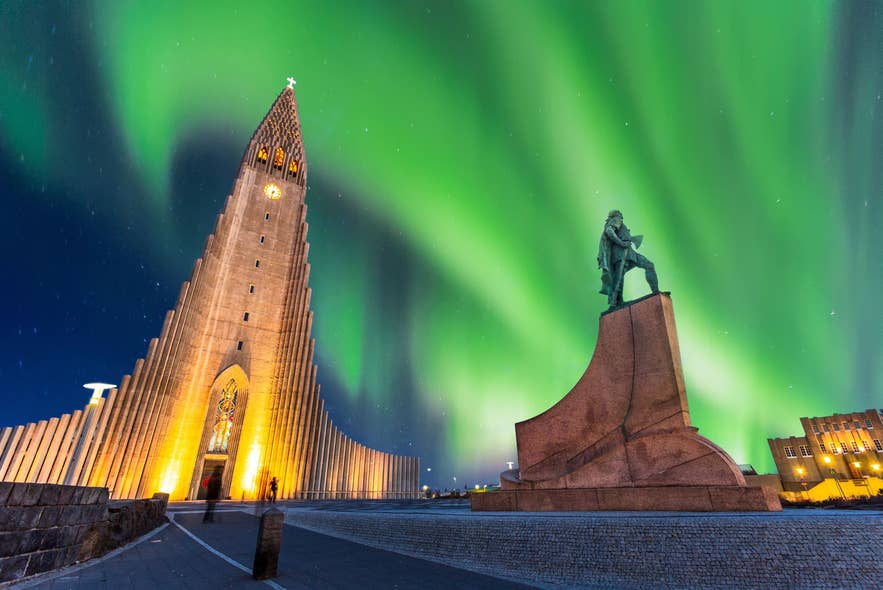 Northern lights above Hallgrímskirkja church and Leifur Eiriksson statue in Reykjavík on a clear February winter night