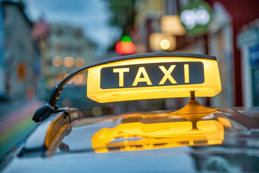 A taxi used for airport transfer in Iceland displays a yellow TAXI logo on its roof near Reykjavik.