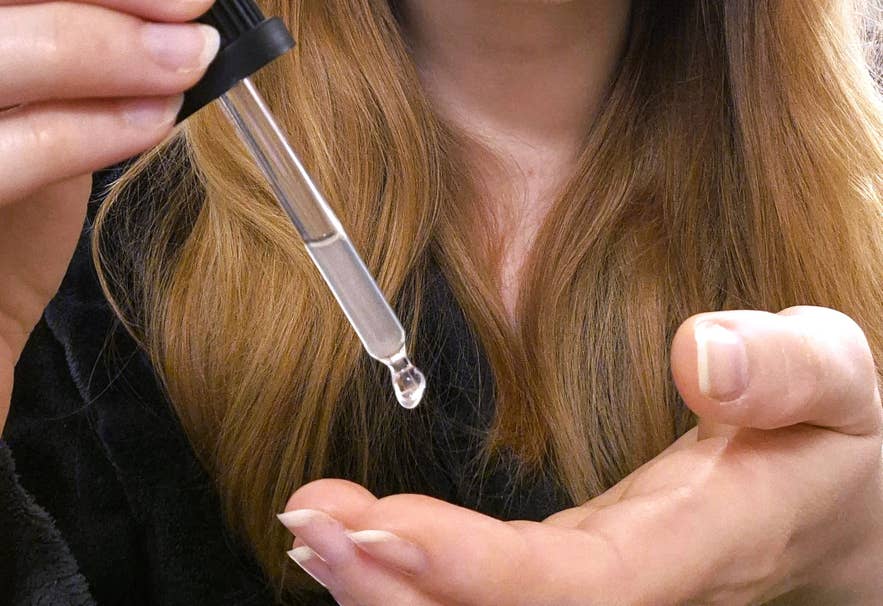 Applying Blue Lagoon BL+ serum with a dropper onto the palm, demonstrating lightweight hydrating skincare for Icelandic winter.