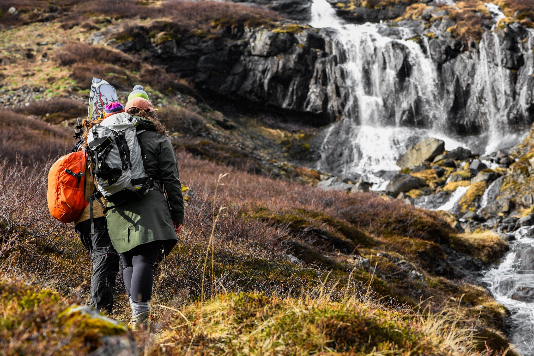 Hikers exploring Dyjandi Waterfall in the Westfjords of Iceland.