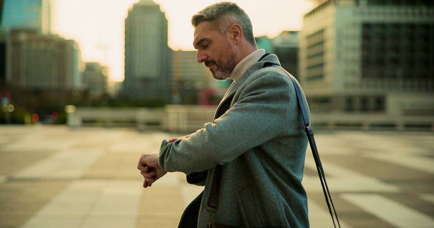 A man checks his watch while walking to his booked airport transfer in Iceland.