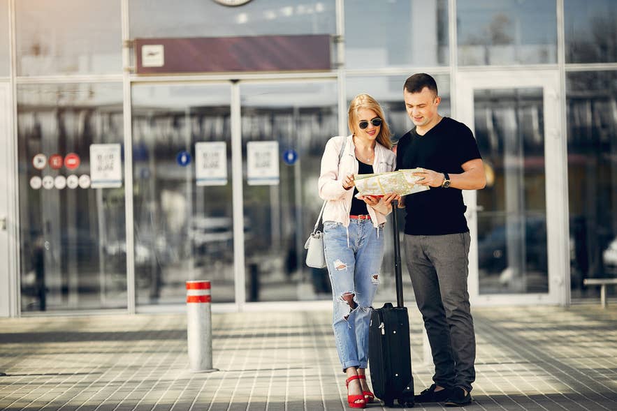 A couple checks a map after arriving in Iceland.