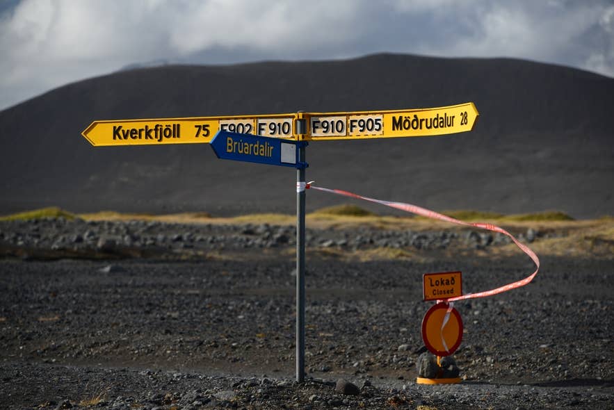 Straßenschilder nach Kverkfjöll und Modrudalur mit einem Sperrschild, das die Hochland-Sperrungen im April zeigt.