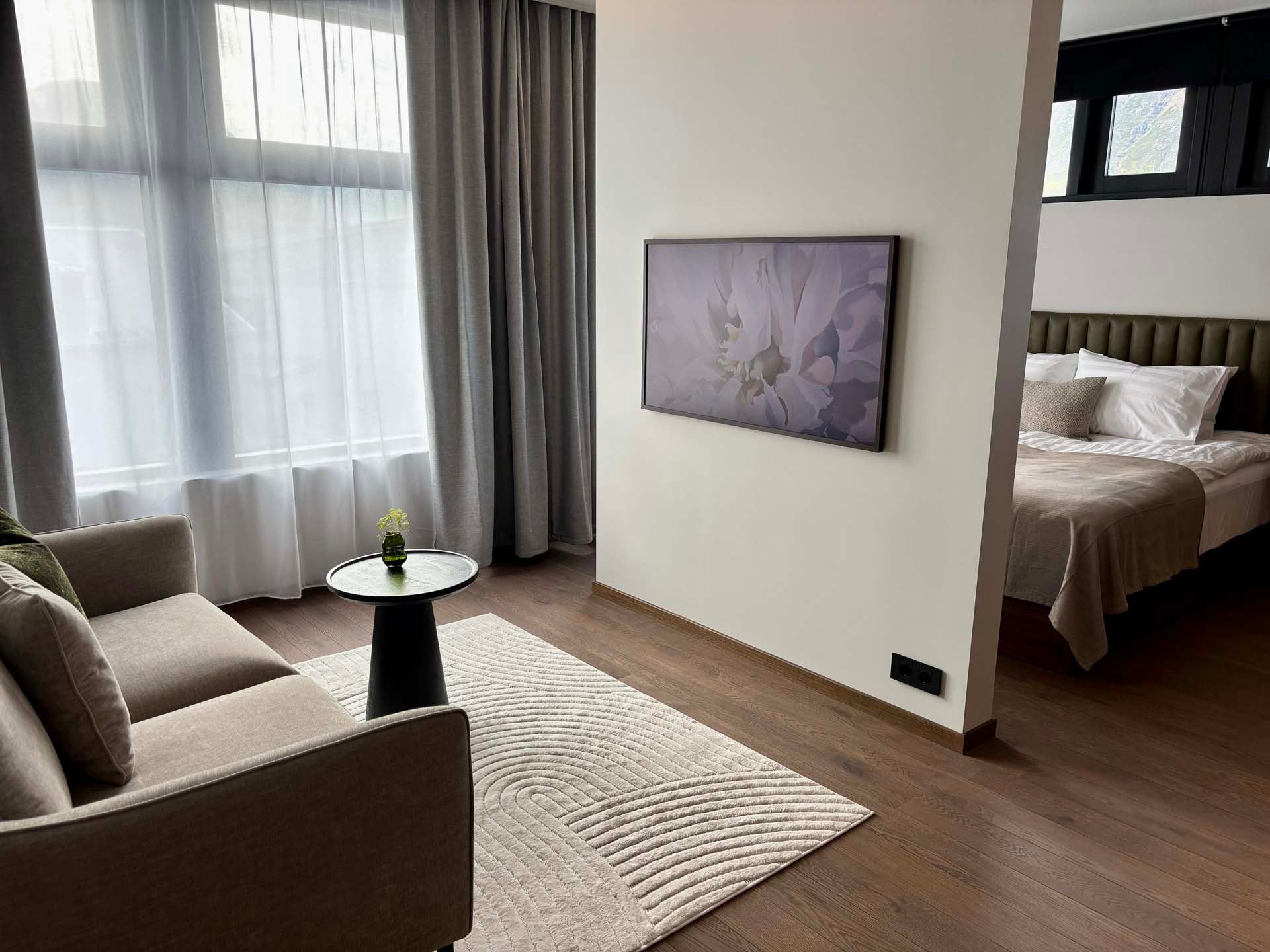 Comfortable seating area with sofa and cozy bedroom in Hvanndalir Lodge.