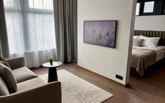 Zona de estar cómoda con sofá y dormitorio acogedor en Hvanndalir Lodge.