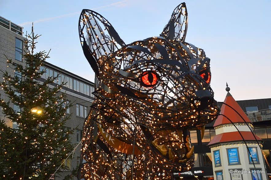 La scultura illuminata del Gatto di Natale con occhi rossi luminosi a Lækjartorg Square a Reykjavik durante il periodo natalizio di dicembre.
